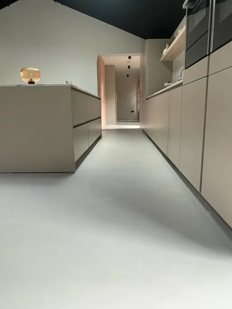 Wide view of seamless microcement floor across open-plan living and kitchen — Beaumaris