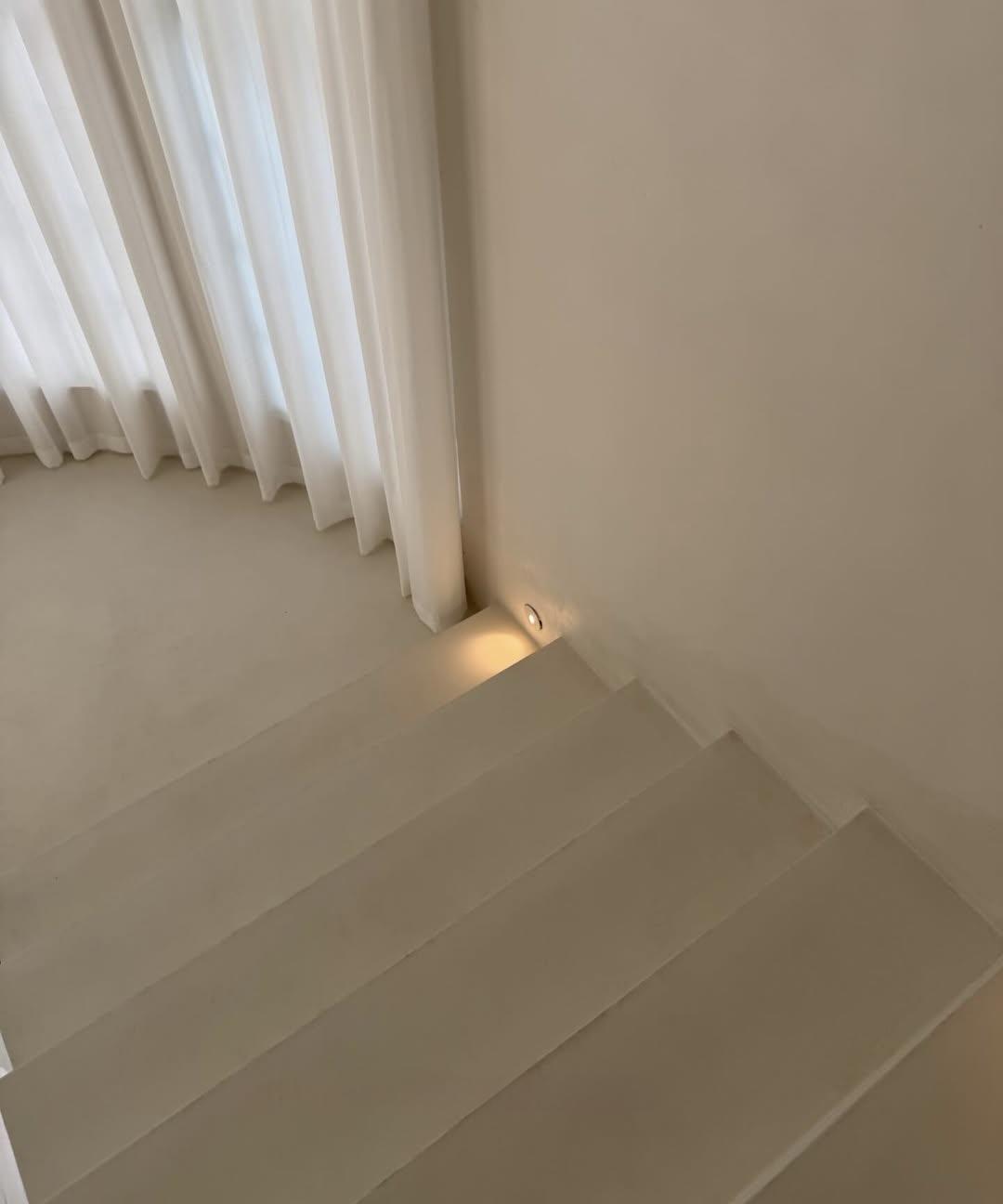 Side angle of microcement staircase showing continuous wall and tread finish — Toorak