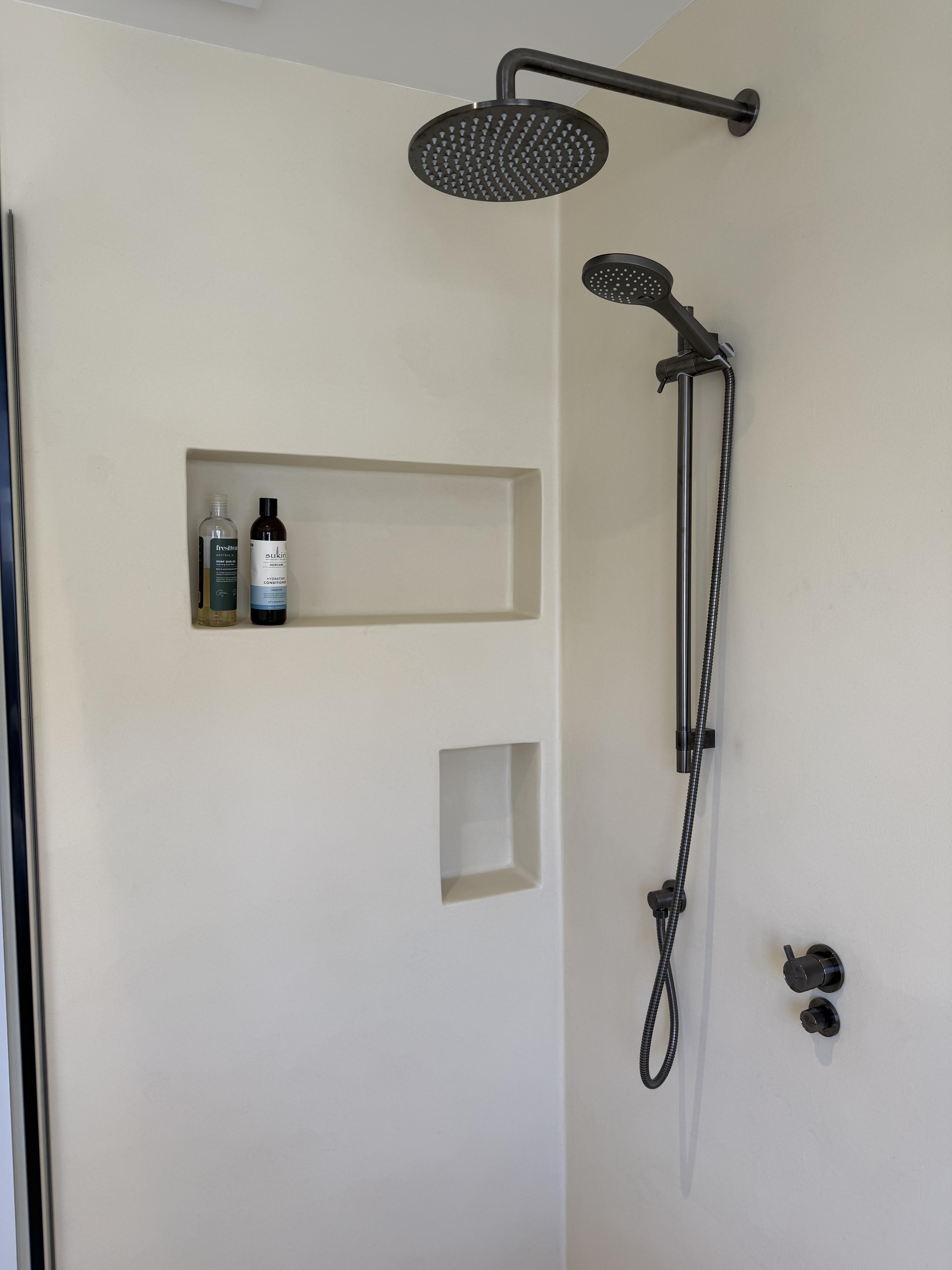 Shower with brushed gunmetal tapware and recessed microcement niches — Malvern